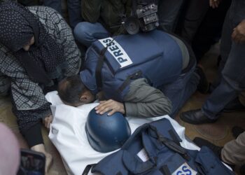 epa11032010 Relatives of Palestinian journalist Samer Abu Daqqa, cameraman for Al Jazeera, who was killed during Israeli air strikes in the southern Gaza Strip, with press crews next to his wrapped body, outside Nasser Hospital in Khan Yunis, southern Gaza Strip, 16 December 2023. More than 18,000 Palestinians and at least 1,200 Israelis have been killed, according to the Palestinian Health Ministry and the Israel Defense Forces (IDF), since Hamas militants launched an attack against Israel from the Gaza Strip on 07 October, and the Israeli operations in Gaza and the West Bank which followed it.  EPA-EFE/HAITHAM IMAD