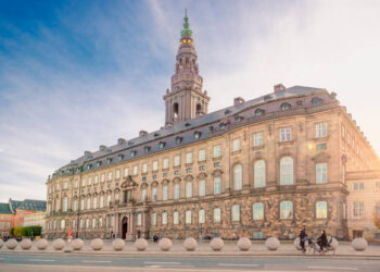 Christiansborg Palace with Christiansborg tower - the seat of the Danish Parliament in the rays of the setting sun. Copenhagen, Denmark